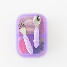 Load image into Gallery viewer, Bumkins Spoon + Fork: Lavender sits atop a purple bento box filled with food on a white background.
