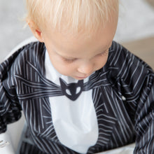 Load image into Gallery viewer, A toddler wearing Bumkins Sleeved Bib: Jack Skellington looks downward.
