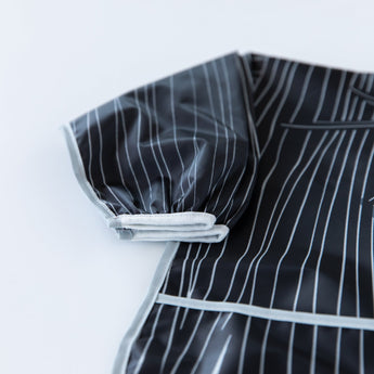 Close-up of Bumkins Sleeved Bib: Jack Skellington on a white background, with focus on the white elastic cuff on the sleeve.