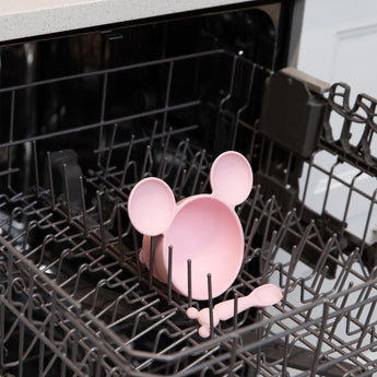 Bumkins Silicone First Feeding Set: Minnie Mouse Light Pink sits in the top rack of an open dishwasher.