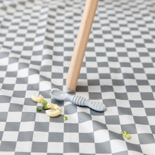Load image into Gallery viewer, A Bumkins Silicone Dipping Spoons 3 Pack: Taffy lays atop a gray &amp; white checkered mat among pieces of pasta &amp; broccoli by a high chair leg.
