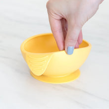 Load image into Gallery viewer, A hand holds a Bumkins Silicone First Feeding Set: Pineapple, demonstrating the suction cup bottom on a marble surface.
