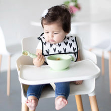 Load image into Gallery viewer, A baby in a high chair wearing a black &amp; white bib holds a green Bumkins Silicone Dipping Spoons 3 Pack: Gumdrop near a green bowl.
