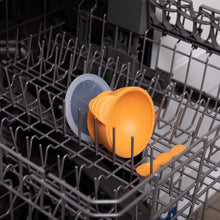 Load image into Gallery viewer, Bumkins Silicone First Feeding Set: Tangerine sits in the top rack of an open dishwasher.
