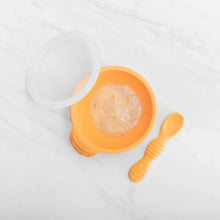 Load image into Gallery viewer, Bumkins Silicone First Feeding Set: Tangerine holds pureed food on a marble background.
