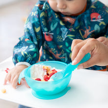 Load image into Gallery viewer, A toddler in a blue bib enjoys yogurt and fruit from a Bumkins Silicone First Feeding Set: Blue Jelly at a high chair with an adult's help.

