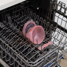 Load image into Gallery viewer, Bumkins Silicone First Feeding Set: Pink Jelly sits in the top rack of an open dishwasher.
