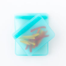 Load image into Gallery viewer, Bumkins Silicone Flat Reusable Bag 2 Pack, Blue filled with bell pepper slices rests on a white background.
