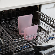 Load image into Gallery viewer, Bumkins Silicone Flat Reusable Bag 2 Pack, Pink sits in the top rack of an open dishwasher.
