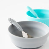 Bumkins Silicone Grip Bowl: Gray with a matching spoon sits in front of a blue bowl and spoon on a white background.