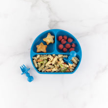 Load image into Gallery viewer, Bumkins Silicone Chewtensils®: Dark Blue and a blue divided plate with pasta, berries, &amp; potatoes rest on a marble background.
