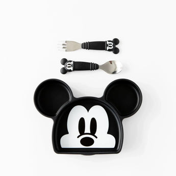 Bumkins Silicone Grip Dish: Mickey Mouse sits below a set of matching utensils on a white background.