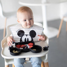 Load image into Gallery viewer, A toddler in a high chair enjoys strawberries and bananas from a Bumkins Silicone Grip Dish: Mickey Mouse while wearing a matching bib.
