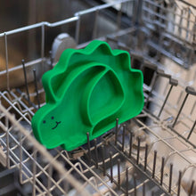 Load image into Gallery viewer, Bumkins Silicone Grip Dish, Special Edition: Dino sits in the top rack of an open dishwasher.
