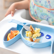 Load image into Gallery viewer, Close-up of a child in a high chair with a Bumkins Silicone Grip Dish: Stitch filled with eggs, pancakes, and orange slices; a fork on top.
