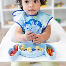 Load image into Gallery viewer, A young girl in a blue bib holds utensils over a Bumkins Silicone Grip Dish: Stitch with pasta, veggies, &amp; fruit on a high chair tray.
