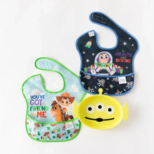 Load image into Gallery viewer, Bumkins Silicone Grip Dish: Toy Story Alien sits among two bibs with cartoon characters on a white background.

