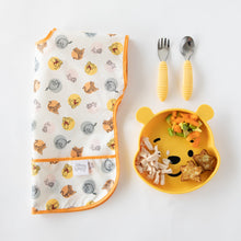 Load image into Gallery viewer, Bumkins Silicone Grip Dish: Winnie The Pooh with chicken and veggies sits near a folded bib and yellow utensils on a white background.
