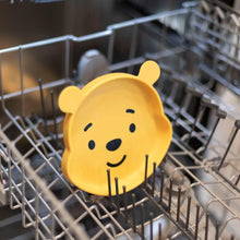 Load image into Gallery viewer, Bumkins Silicone Grip Dish: Winnie The Pooh sits in the top rack of an open dishwasher.

