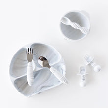 Load image into Gallery viewer, Utensils sit on top of a Bumkins Silicone Grip Dish: Marble on a white background, with toddler utensils and a bowl &amp; spoon set nearby.
