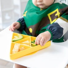 Load image into Gallery viewer, A child in a high chair enjoys avocado, broccoli, and snacks from a Bumkins Silicone Grip Dish: Zelda™ Triforce on the tray.
