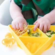 Load image into Gallery viewer, Close-up of a toddler enjoying spaghetti, kiwi, and veggies from a Bumkins Silicone Grip Dish: Zelda™ Triforce on a high chair tray.
