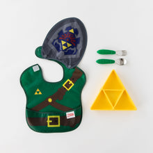 Load image into Gallery viewer, Bumkins Silicone Grip Dish: Zelda™ Triforce sits next to green handle utensils and a waterproof bib with a cape on a white background.
