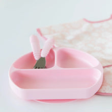 Load image into Gallery viewer, Bumkins Silicone Grip Dish: Pink holds matching utensils next to a pink floral bib on a white background.
