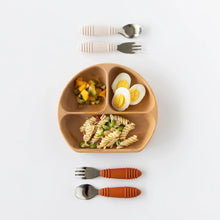Load image into Gallery viewer, Bumkins Silicone Grip Dish: Wood Grain holds pasta, eggs, and fruit salad on a white background, with two sets of utensils above and below.
