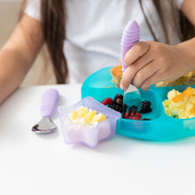 Load image into Gallery viewer, A child enjoys breakfast from a Bumkins Silicone Grip Dish: Blue Jelly, using a lavender fork, with yogurt and pineapple in a star bowl.
