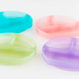 Four colorful dishes, including Bumkins Silicone Grip Dish: Green Jelly, are arranged on a white background.