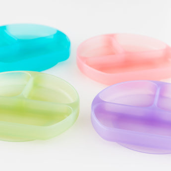 Four colorful dishes, including Bumkins Silicone Grip Dish: Green Jelly, are arranged on a white background.