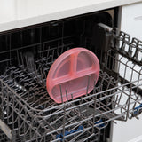 Bumkins Silicone Grip Dish: Pink Jelly sits in the top rack of an open dishwasher.