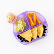 Load image into Gallery viewer, Bumkins Silicone Grip Dish: Purple Jelly holds carrots, cucumbers, beans, and tortillas with a heart cup of hummus on a white background.
