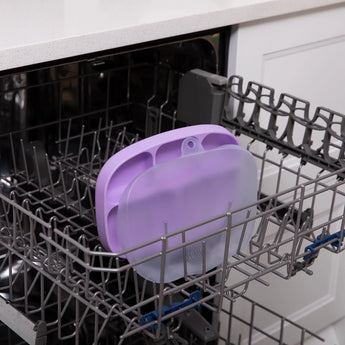 Bumkins Silicone Grip Dish with Lid (5 Section): Lavender sits in the top rack of an open dishwasher.