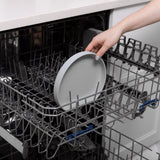 A hand places a Bumkins Silicone Grip Plate: Gray into the top rack of an open dishwasher.
