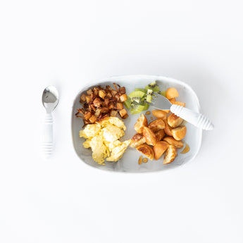 Bumkins Silicone Grip Tray: Marble holds breakfast foods and fruit with matching utensils on a white background.