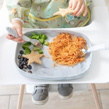 Load image into Gallery viewer, A child in a high chair enjoys pasta, broccoli, and blueberries from a Bumkins Silicone Grip Tray: Marble with a fork.
