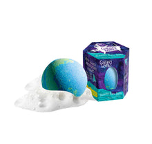 Load image into Gallery viewer, A plant-based blue/green bath bomb with white foam rests next to a purple/blue hexagonal Galaxy box by Loot Toys.
