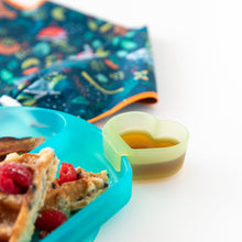 Load image into Gallery viewer, Close-up of a Bumkins Silicone Little Dipper Combo 2 Pack: Aqua Jelly with syrup next to a plate of waffles and a bib on a white background.
