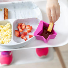 Load image into Gallery viewer, Close-up of a child in a high chair dipping bread in sauce from a fuchsia Bumkins Silicone Little Dipper 3-Pack: Lollipop next to a plate.
