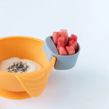 Load image into Gallery viewer, An orange bowl with yogurt, with a gray Bumkins Silicone Little Dipper Round 3-Pack: Taffy holding watermelon on a white background.
