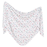 Copper Pearls Knit Swaddle Blanket, Minnie Mouses Bowquet is a white shawl with butterfly and flower patterns in a cozy triangular shape.