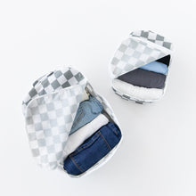 Load image into Gallery viewer, Bumkins Packing Cube 2 Pack: Charcoal Check sits open, holding neatly folded clothes, including denim, on a white background.
