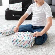 Load image into Gallery viewer, A child sits on a carpet, zipping a Bumkins Packing Cube 2 Pack: Mickey &amp; Friends Varsity with an open suitcase in background.

