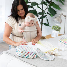 Load image into Gallery viewer, A woman wearing a baby in a carrier folds clothes on a bed to put in Bumkins Packing Cube 2 Pack: Mickey &amp; Friends Varsity.
