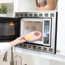 Load image into Gallery viewer, A hand places Bumkins Silicone Plate + Spoon Set: Disney Princess with eggs and sausage into an open microwave.
