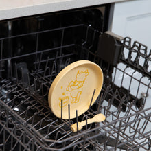 Load image into Gallery viewer, Bumkins Silicone Plate + Spoon Set: Disney Winnie the Pooh sits in the top rack of an open dishwasher.
