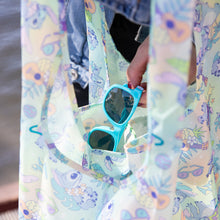 Load image into Gallery viewer, Close-up of a person putting blue sunglasses into a Bumkins Packable Tote Bag: Aloha Stitch.
