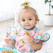 Load image into Gallery viewer, A toddler with a ponytail enjoys waffles in a high chair, wearing a Bumkins Ruffle Apron Bib: Boots in a bright room.
